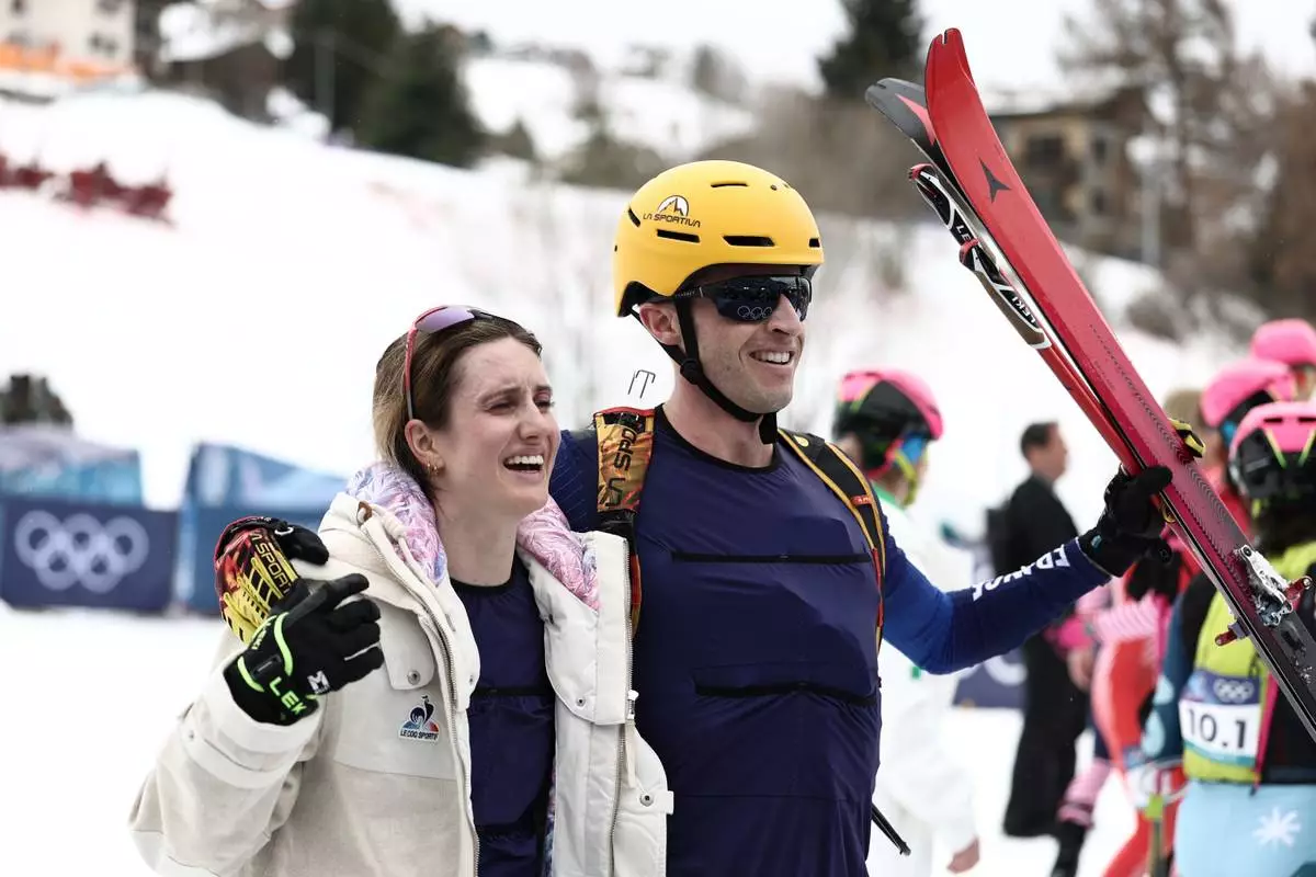 France's Emily Harrop, left, and France's Thibault Anselmet celebrate winning gold in a ski mountaineering mixed relay, at the 2026 Winter Olympics, in Bormio, Italy, Saturday, Feb. 21, 2026. (AP Photo/Gabriele Facciotti)