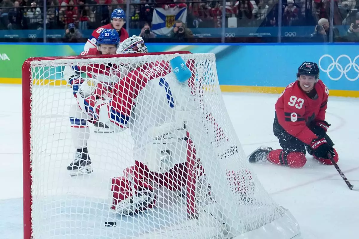 Canada's Mitch Marner (93) scores the winning goal during the overtime period of a men's ice hockey quarterfinal game between Canada and Czechia at the 2026 Winter Olympics, in Milan, Italy, Wednesday, Feb. 18, 2026. (Darryl Dyck/The Canadian Press via AP)