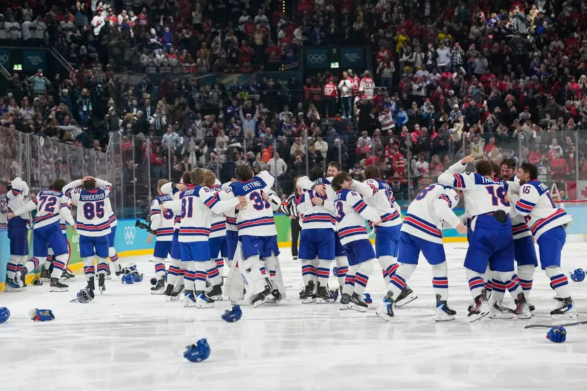 United States players celebrate after scoring during a men's ice hockey gold medal game between Canada and the United States at the 2026 Winter Olympics, in Milan, Italy, Sunday, Feb. 22, 2026. (AP Photo/Hassan Ammar)