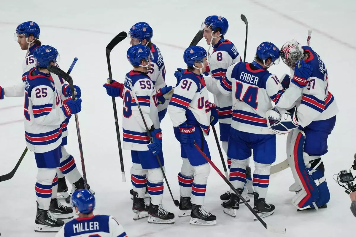 United States players line up to congratulate goalkeeper Connor Hellebuyck (37) after their win over Slovakia in a men's ice hockey semifinal game at the 2026 Winter Olympics in Milan, Italy, Friday, Feb. 20, 2026. (AP Photo/Carolyn Kaster)