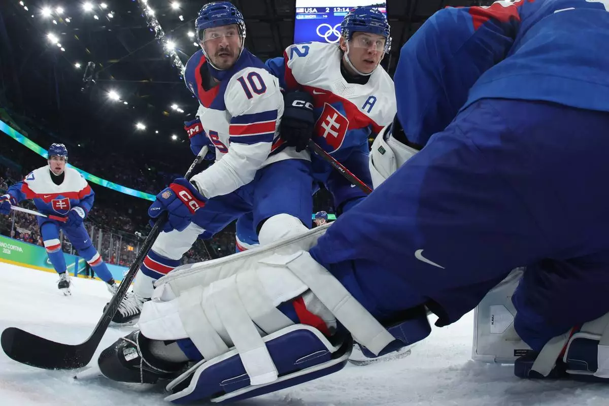 United States' JT Miller (10) challenges with Slovakia's Martin Fehervary (42) during a men's ice hockey semifinal game between the United States and Slovakia at the 2026 Winter Olympics, in Milan, Italy, Friday, Feb. 20, 2026. (Bruce Bennett/Pool Photo via AP)