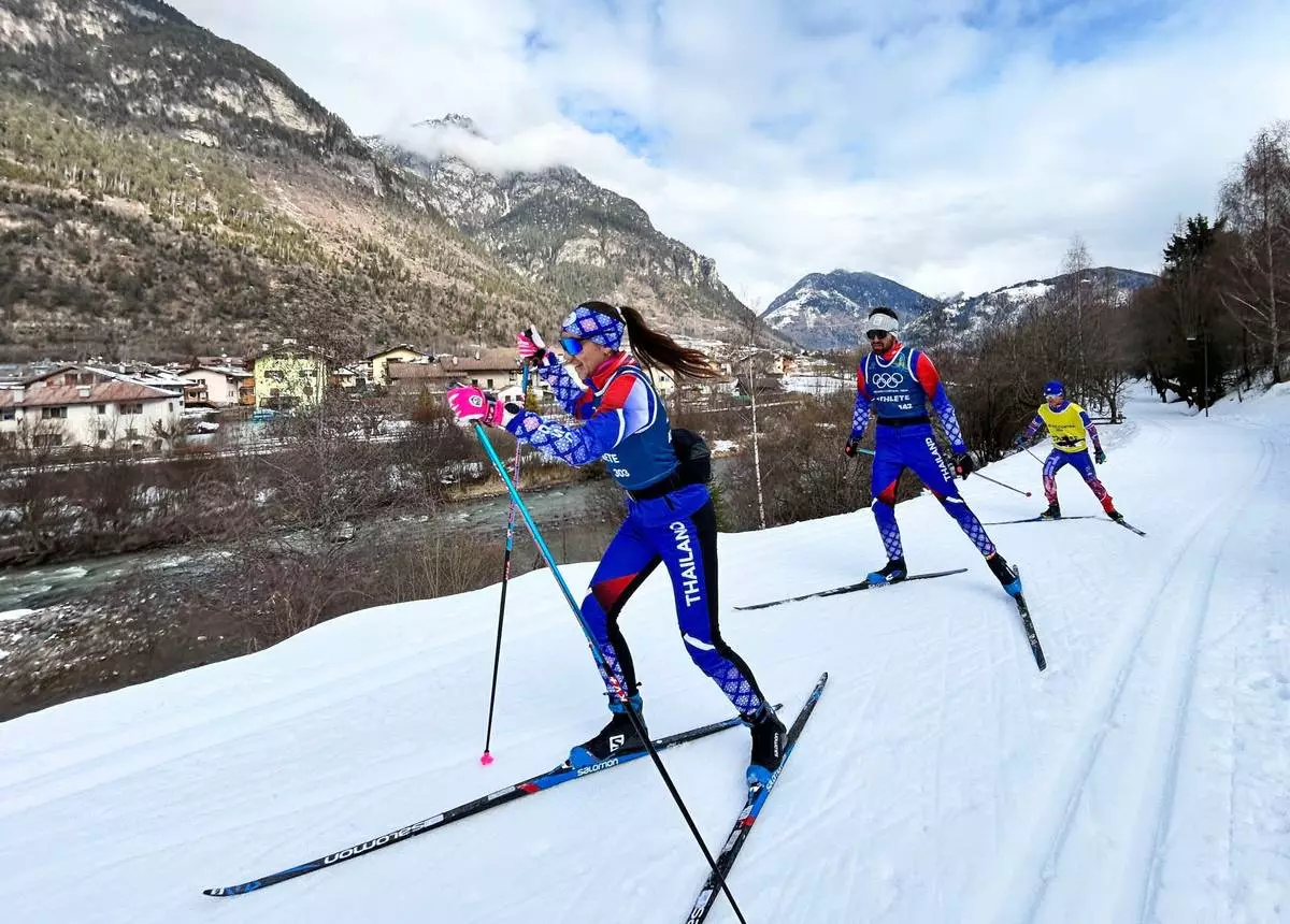 Olympic cross-country skiers from Thailand ski along the Marcialonga trail, during the 2026 Winter Olympics, in Ziano di Fiemme, Italy, Saturday, Feb. 7, 2026. (AP Photo/Brian Melley)