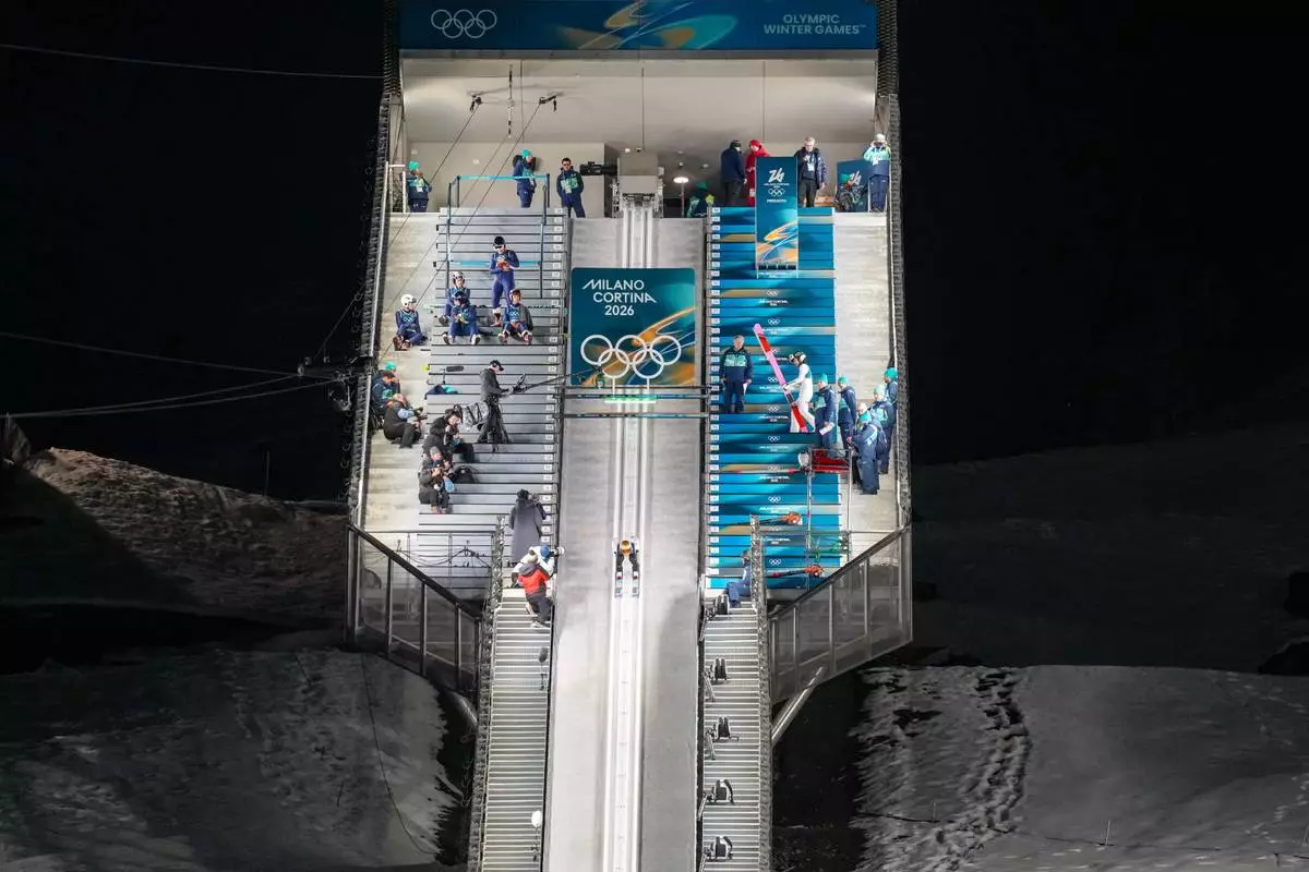 Domen Prevc, of Slovenia, goes down the ramp during his trial jump of the ski jumping men's normal hill individual at the 2026 Winter Olympics, in Predazzo, Italy, Monday, Feb. 9, 2026. (AP Photo/Evgeniy Maloletka)