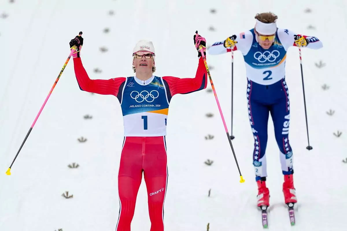 Johannes Hoesflot Klaebo, of Norway, crosses the finish line to win the gold medal in the cross-country skiing men's sprint classic at the 2026 Winter Olympics, in Tesero, Italy, Tuesday, Feb. 10, 2026. (AP Photo/Matthias Schrader)