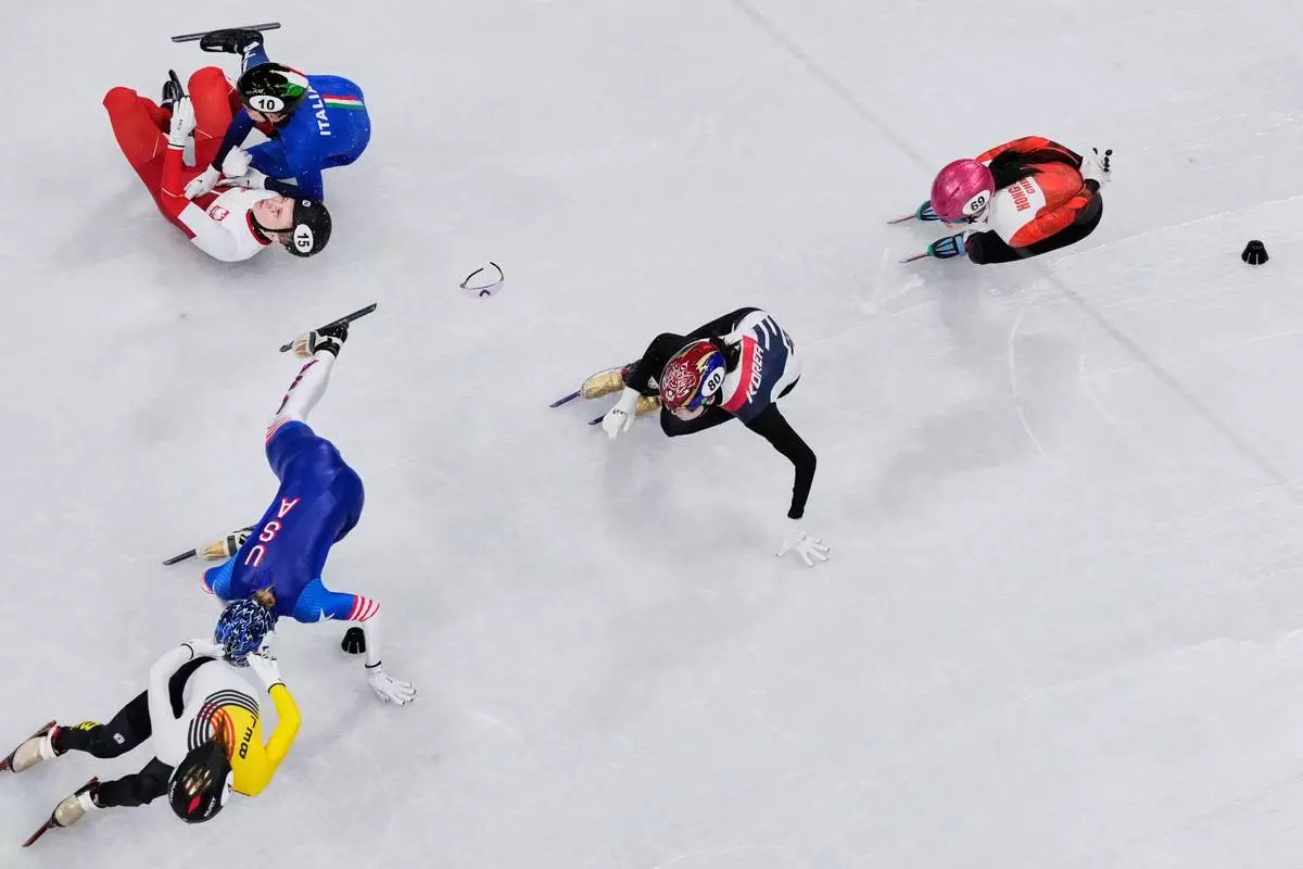 Kamila Sellier of Poland, 15, Arianna Fontana of Italy, 10, and Kristen Santos-Griswold of the United States fall during a short track speed skating women's 1500 meters quarterfinal at the 2026 Winter Olympics, in Milan, Italy, Friday, Feb. 20, 2026. (AP Photo/Bernat Armangue)