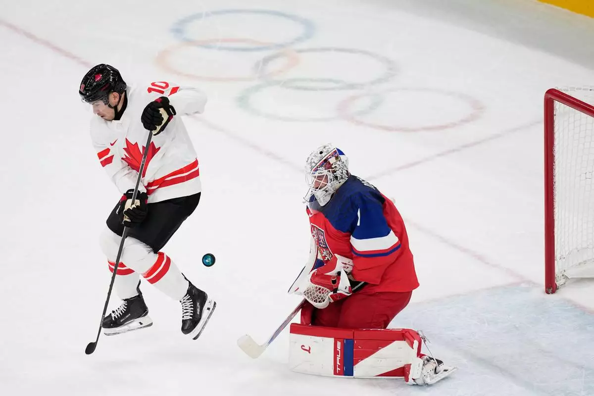 during a preliminary round match of men's ice Czechia's goalkeeper Lukas Dostal, right, makes a save against Canada's Nick Suzuki hockey between Czech Republic and Canada at the 2026 Winter Olympics, in Milan, Italy, Thursday, Feb. 12, 2026. (AP Photo/Petr David Josek)