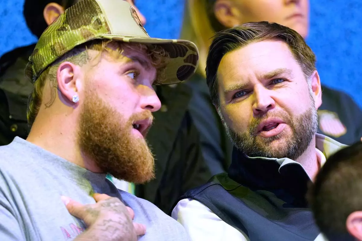 Jake Paul, left, and Vice President JD Vance attend a preliminary round match of women's ice hockey between the United States and Finland at the 2026 Winter Olympics, in Milan, Italy, Saturday, Feb. 7, 2026. (AP Photo/Petr David Josek)