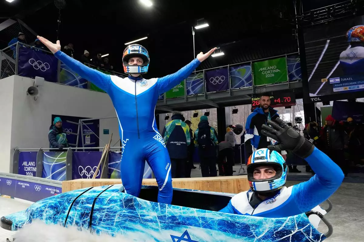 Israel's Adam Edelman, left, and Menachem Chen celebrate at the end of a two man bobsled run at the 2026 Winter Olympics, in Cortina d'Ampezzo, Italy, Monday, Feb. 16, 2026. (AP Photo/Alessandra Tarantino)