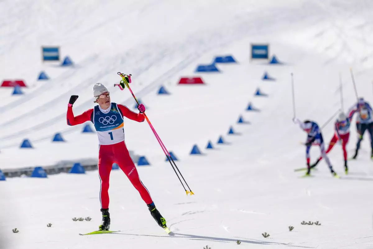 Johannes Hoesflot Klaebo, of Norway, approaches the finish line to win the gold medal in the cross country skiing men's 10km + 10km skiathlon at the 2026 Winter Olympics, in Tesero, Italy, Sunday, Feb. 8, 2026. (AP Photo/Evgeniy Maloletka)