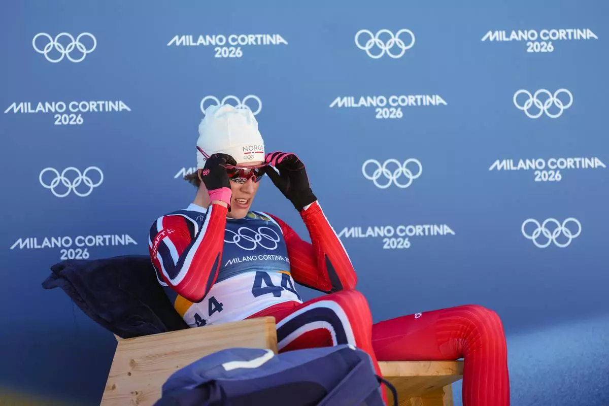 Johannes Hoesflot Klaebo, of Norway, sits on the leader's chair after crossing the finish line in the the cross country skiing men's 10km interval start free at the 2026 Winter Olympics, in Tesero, Italy, Friday, Feb. 13, 2026. (AP Photo/Evgeniy Maloletka)