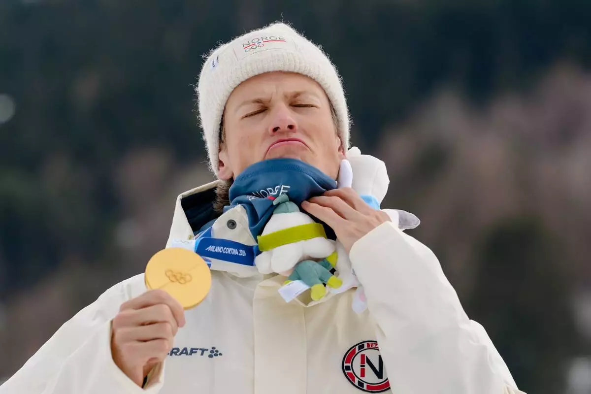 Gold medalist Johannes Hoesflot Klaebo, of Norway, poses on the podium of the cross-country skiing men's sprint classic at the 2026 Winter Olympics, in Tesero, Italy, Tuesday, Feb. 10, 2026. (AP Photo/Evgeniy Maloletka)