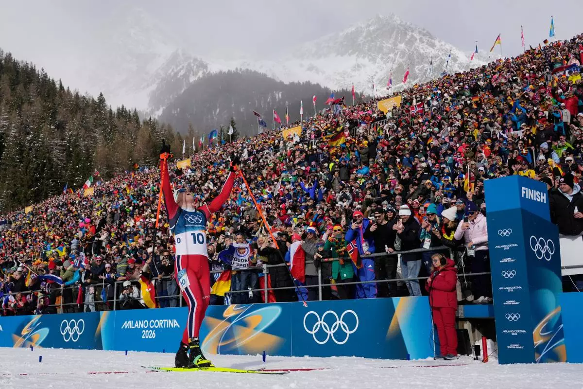 Johannes Dale-Skjevdal, of Norway, crosses the finish line to win gold in the men's 15-kilometer mass start biathlon race at the 2026 Winter Olympics in Anterselva, Italy, Friday, Feb. 20, 2026. (AP Photo/David J. Phillip)