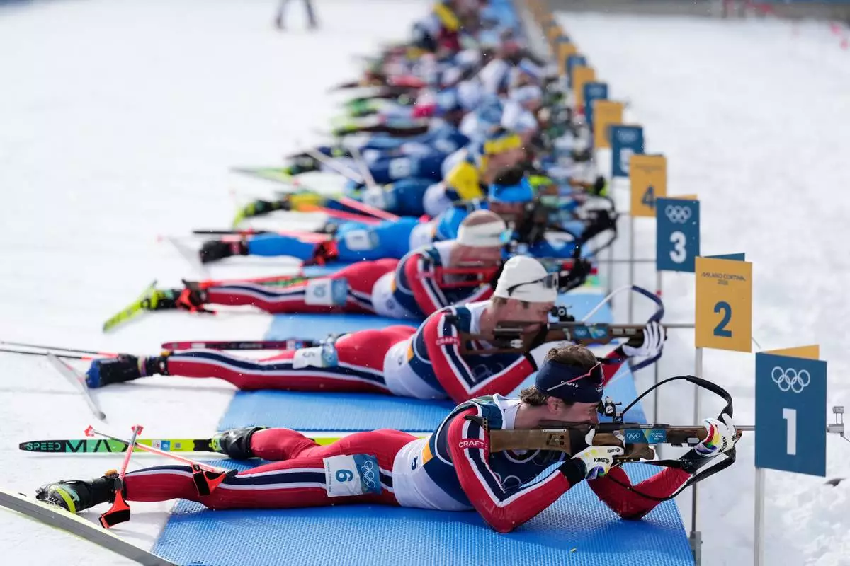 Sturla Holm Laegreid, of Norway, front, competes in the men's 15-kilometer mass start biathlon race at the 2026 Winter Olympics in Anterselva, Italy, Friday, Feb. 20, 2026. (AP Photo/Mosa'ab Elshamy)