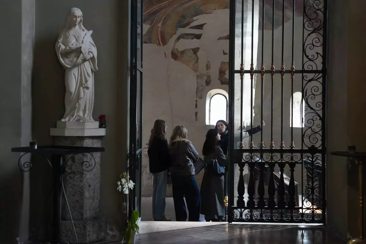 Giovanna Giuditta Mazza, right, leads a small group of visitors inside the Basilica of San Lorenzo Maggiore as part of the “La Via della Bellezza,” or “The Path of Beauty,” initiative in Milan, Italy, Wednesday, Feb. 18, 2026. Volunteers with the archdiocese’s youth ministry office offer free visits highlighting the artistic and spiritual heritage of the churches. (AP Photo/María Teresa Hernández)