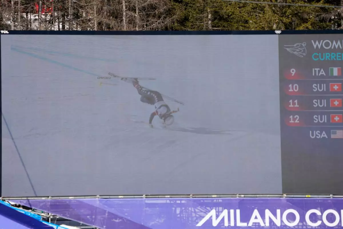 United States' Lindsey Vonn's crash is seen on a giant screen at the finish area of an alpine ski women's downhill race, at the 2026 Winter Olympics, in Cortina d'Ampezzo, Italy, Sunday, Feb. 8, 2026. (AP Photo/Andy Wong)