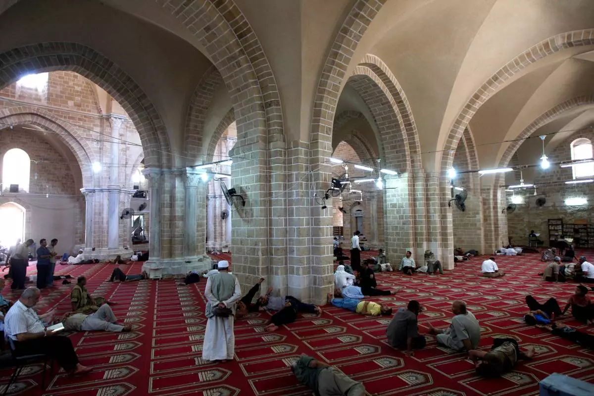 FILE - Palestinian men rest or pray in the Great Omari Mosque in Gaza City during the Muslim holy month of Ramadan before it was damaged by an Israeli strike during the war with Hamas, Tuesday, Aug. 17, 2010. (AP Photo/ Khalil Hamra, File)