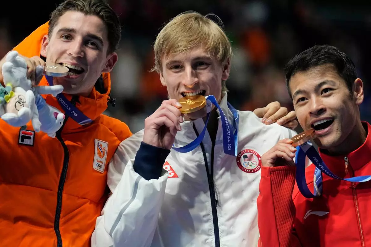 Gold medallist Jordan Stolz of the U.S., center, Jenning de Boo of the Netherlands, left and silver medal, and Ning Zhongyan of China, right and bronze medal, celebrate on the podium of the men's 1,000 meters speedskating race at the 2026 Winter Olympics, in Milan, Italy, Wednesday, Feb. 11, 2026. (AP Photo/Luca Bruno)