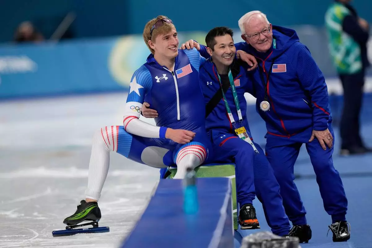 Jordan Stolz of the U.S. and coach Bob Corby, right, pose for a picture after the men's 1,000 meters speedskating race at the 2026 Winter Olympics, in Milan, Italy, Wednesday, Feb. 11, 2026. (AP Photo/Luca Bruno)