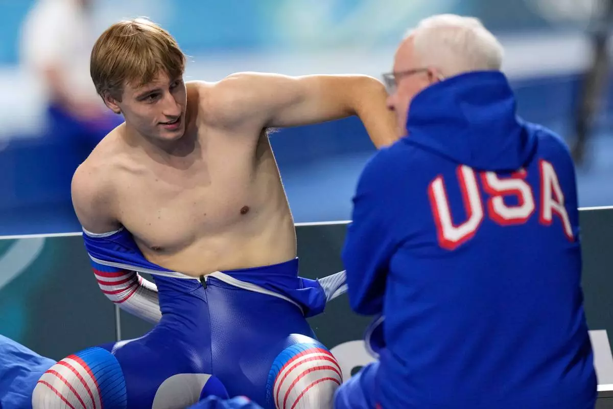 Jordan Stolz of the U.S. talks to coach Bob Corby, right, before the men's 1,000 meters speedskating race at the 2026 Winter Olympics, in Milan, Italy, Wednesday, Feb. 11, 2026. (AP Photo/Luca Bruno)