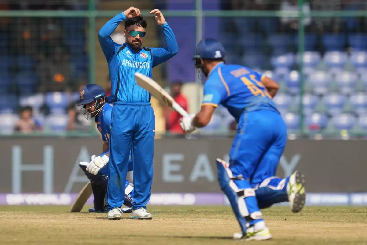 Afghanistan's captain Rashid Khan, centre, watches United Arab Emirates' Sohaib Khan after bowls a delivery during the T20 World Cup cricket match between Afghanistan and United Arab Emirates in New Delhi, India, Monday, Feb. 16, 2026. (AP Photo/Manish Swarup)