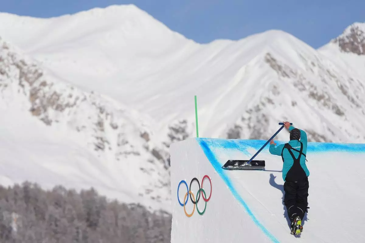 A worker preps a ramp before a freestyle skiing slopestyle training session at the 2026 Winter Olympics, in Livigno, Italy, Thursday, Feb. 5, 2026. (AP Photo/Lindsey Wasson)