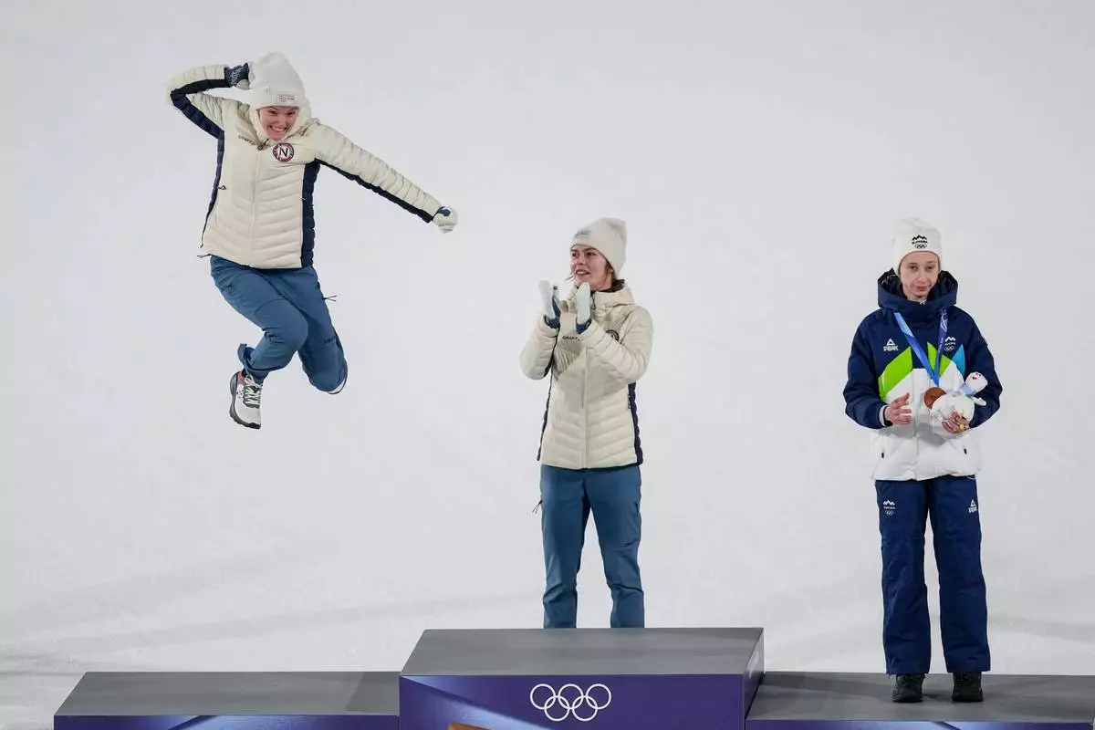 Gold medalist Anna Odine Stroem, of Norway, applauds as silver medalist Eirin Maria Kvandal, also of Norway, celebrates and bronze medalist Nika Prevc, of Slovenia, right, applauds after the ski jumping women's large hill individual at the 2026 Winter Olympics, in Predazzo, Italy, Sunday, Feb. 15, 2026. (AP Photo/Matthias Schrader)