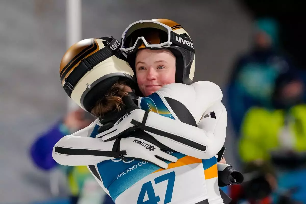 Silver medalist Eirin Maria Kvandal, of Norway, right, hugs gold medalist Anna Odine Stroem, also of Norway, after the ski jumping women's large hill individual at the 2026 Winter Olympics, in Predazzo, Italy, Sunday, Feb. 15, 2026. (AP Photo/Kirsty Wigglesworth)