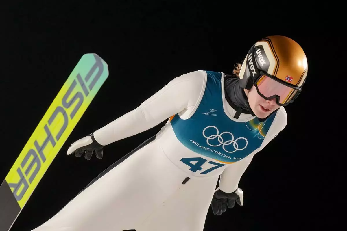 Anna Odine Stroem, of Norway, soars through the air during her first round jump of the ski jumping women's large hill individual at the 2026 Winter Olympics, in Predazzo, Italy, Sunday, Feb. 15, 2026. (AP Photo/Evgeniy Maloletka)