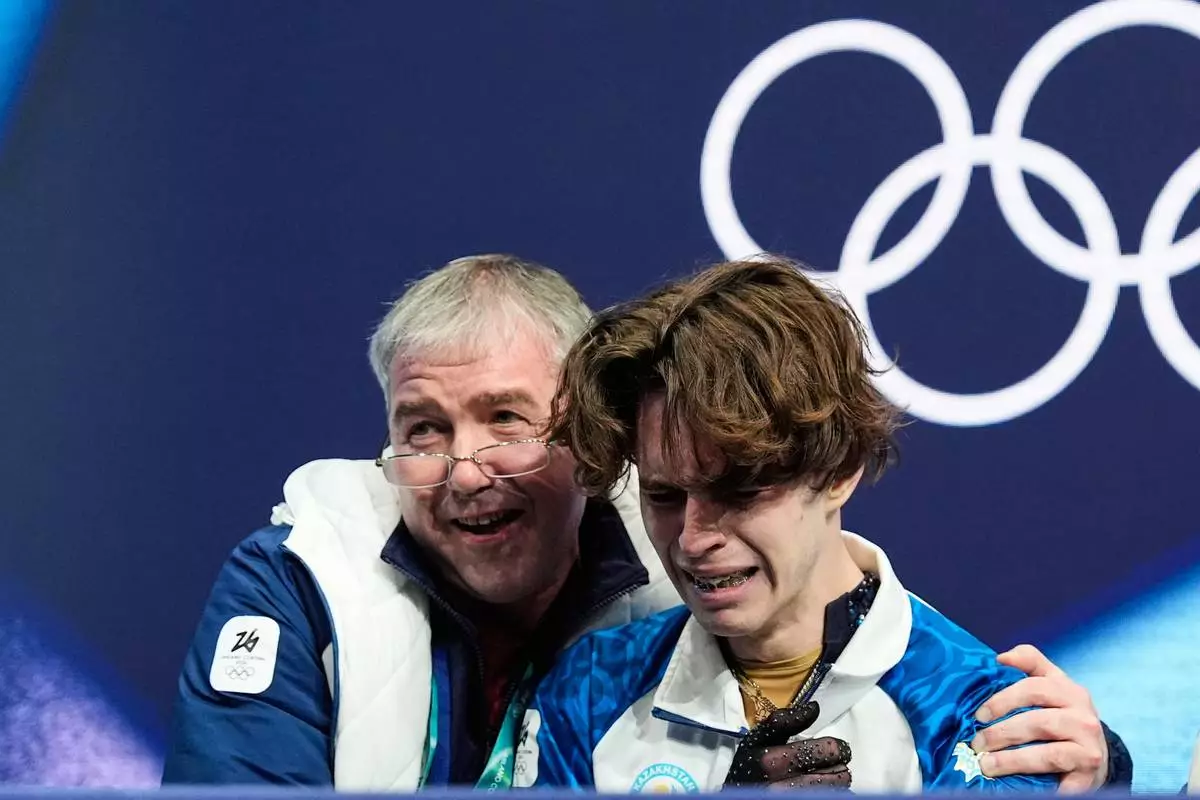Mikhail Shaidorov of Kazakhstan reacts to his scores after competing during the men's free skate program in figure skating at the 2026 Winter Olympics, in Milan, Italy, Friday, Feb. 13, 2026. (AP Photo/Ashley Landis)