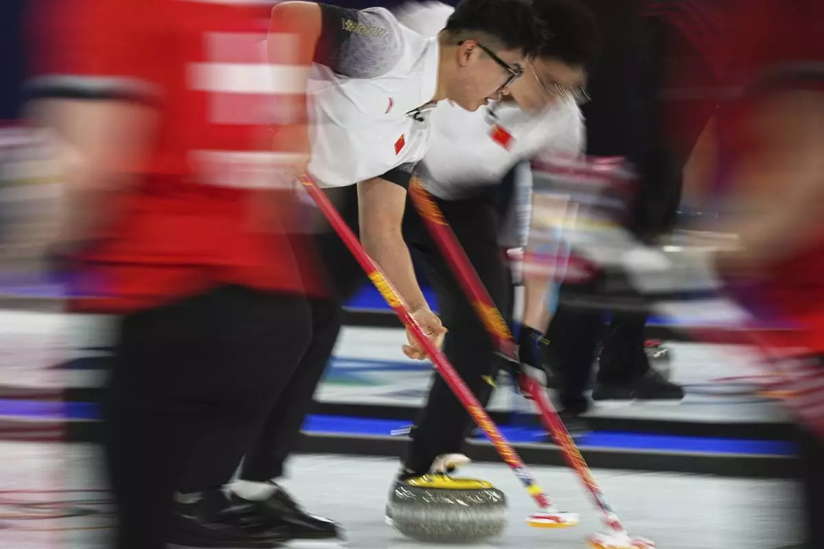 China's Xu Xiaoming and Xu Jingtao in action during the men's curling round robin session against Switzerland at the 2026 Winter Olympics, in Cortina d'Ampezzo, Italy, Saturday, Feb.14, 2026. (AP Photo/Fatima Shbair)