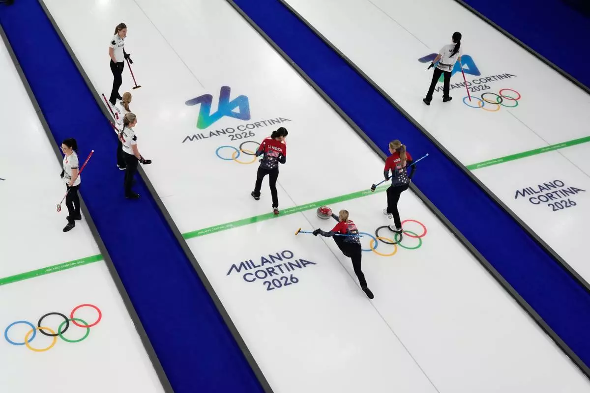 United States' Tabitha Peterson, Cory Thiesse and Taylor Anderson-Heide compete during a women's curling round robin match against Canada at the 2026 Winter Olympics, in Cortina d'Ampezzo, Italy, Friday, Feb. 13, 2026. (AP Photo/David J. Phillip)