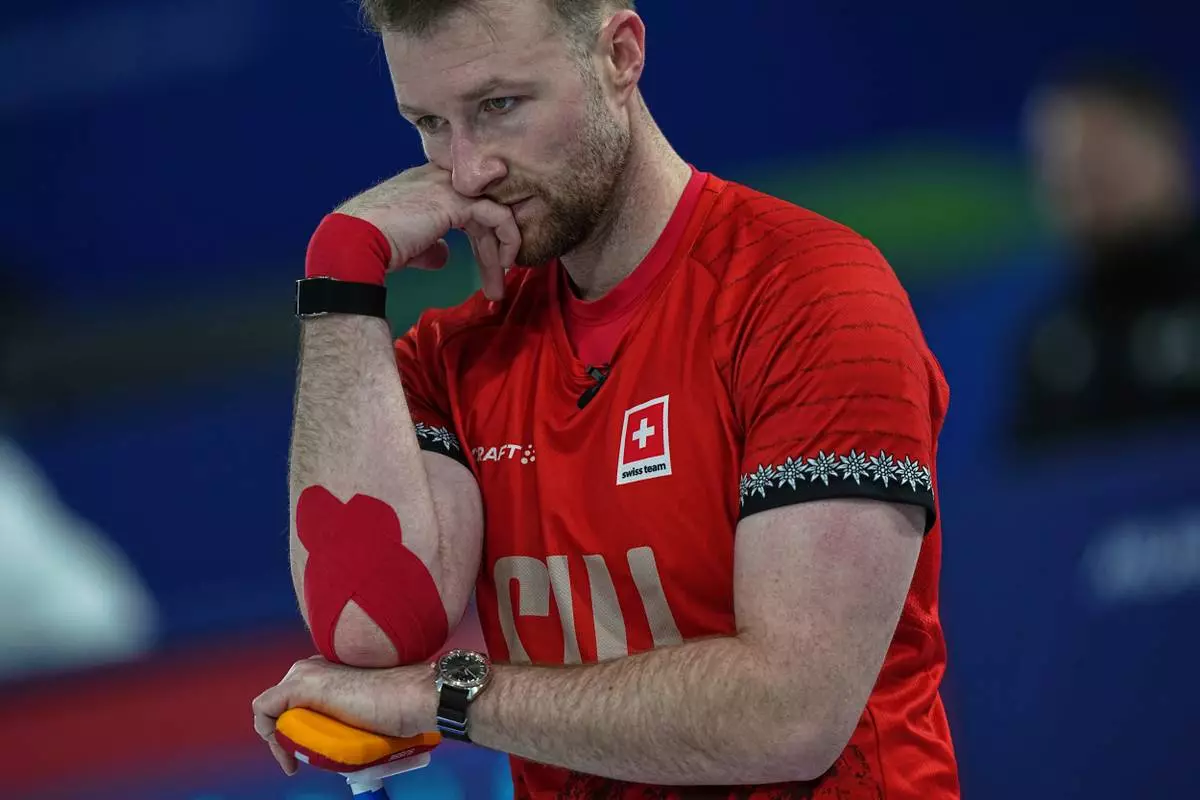 Switzerland's Yannick Schwaller competes during the mixed doubles round robin phase of the curling competition against Canada at the 2026 Winter Olympics, in Cortina d'Ampezzo, Italy, Monday, Feb. 9, 2026. (AP Photo/Fatima Shbair)