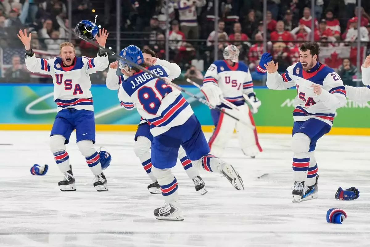 United States players celebrate after scoring during a men's ice hockey gold medal game between Canada and the United States at the 2026 Winter Olympics, in Milan, Italy, Sunday, Feb. 22, 2026. (AP Photo/Hassan Ammar)