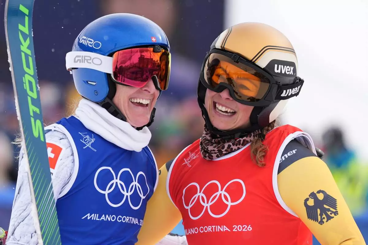 Silver medalist Switzerland's Fanny Smith (3), left, and gold medalist Germany's Daniela Maier (1) embrace after the women's ski cross finals at the 2026 Winter Olympics, in Livigno, Italy, Friday, Feb. 20, 2026. (AP Photo/Rebecca Blackwell)