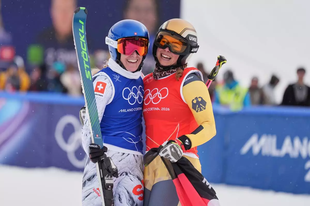 Switzerland's Fanny Smith (3), left, and Germany's Daniela Maier (1) embrace after the women's ski cross finals at the 2026 Winter Olympics, in Livigno, Italy, Friday, Feb. 20, 2026. (AP Photo/Rebecca Blackwell)