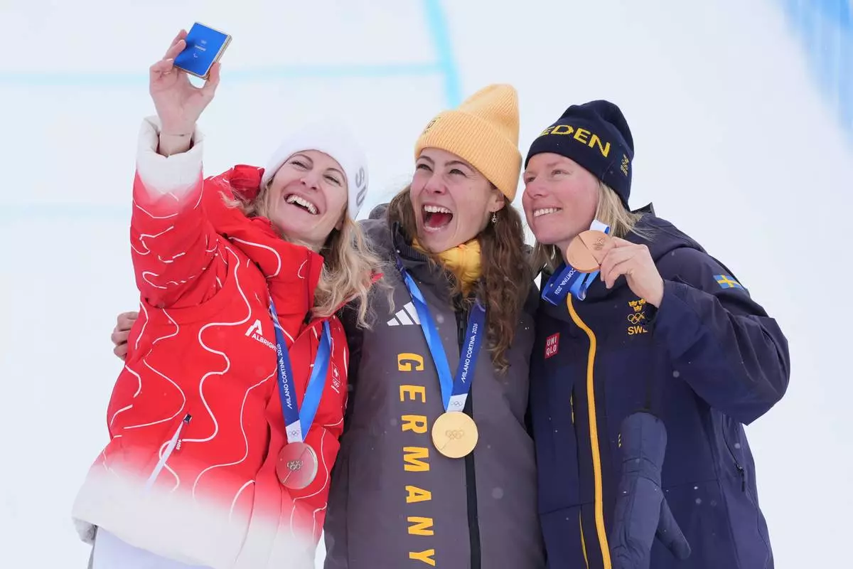 From left, silver medalist Switzerland's Fanny Smith (3), gold medalist Germany's Daniela Maier (1), and bronze medalist Sweden's Sandra Naeslund (2) celebrate after the women's ski cross finals at the 2026 Winter Olympics, in Livigno, Italy, Friday, Feb. 20, 2026. (AP Photo/Rebecca Blackwell)