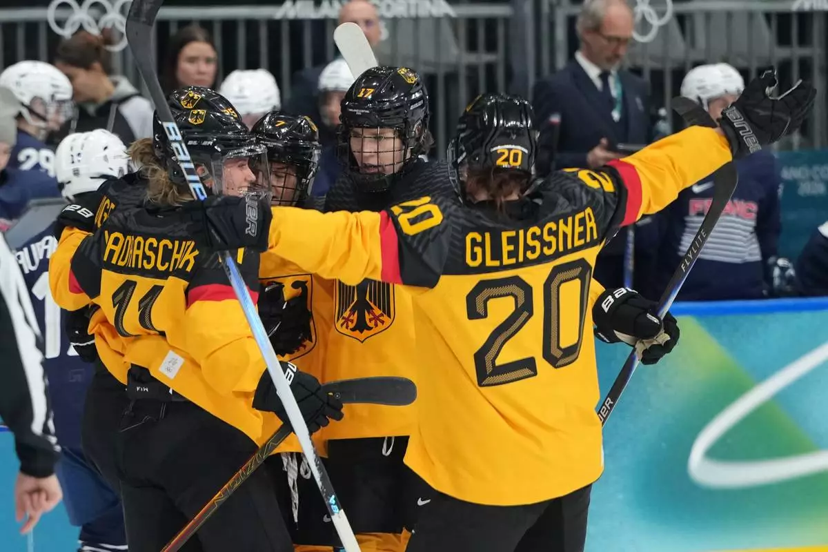 Germany's Laura Kluge (25), at left, celebrates with teammates including Nicola Hadraschek (11) and Daria Gleissner (20) and Emily Nix (17), after scoring a goal in the first period against France during a preliminary round match of women's ice hockey at the 2026 Winter Olympics, in Milan, Italy, Monday, Feb. 9, 2026. (AP Photo/Carolyn Kaster)