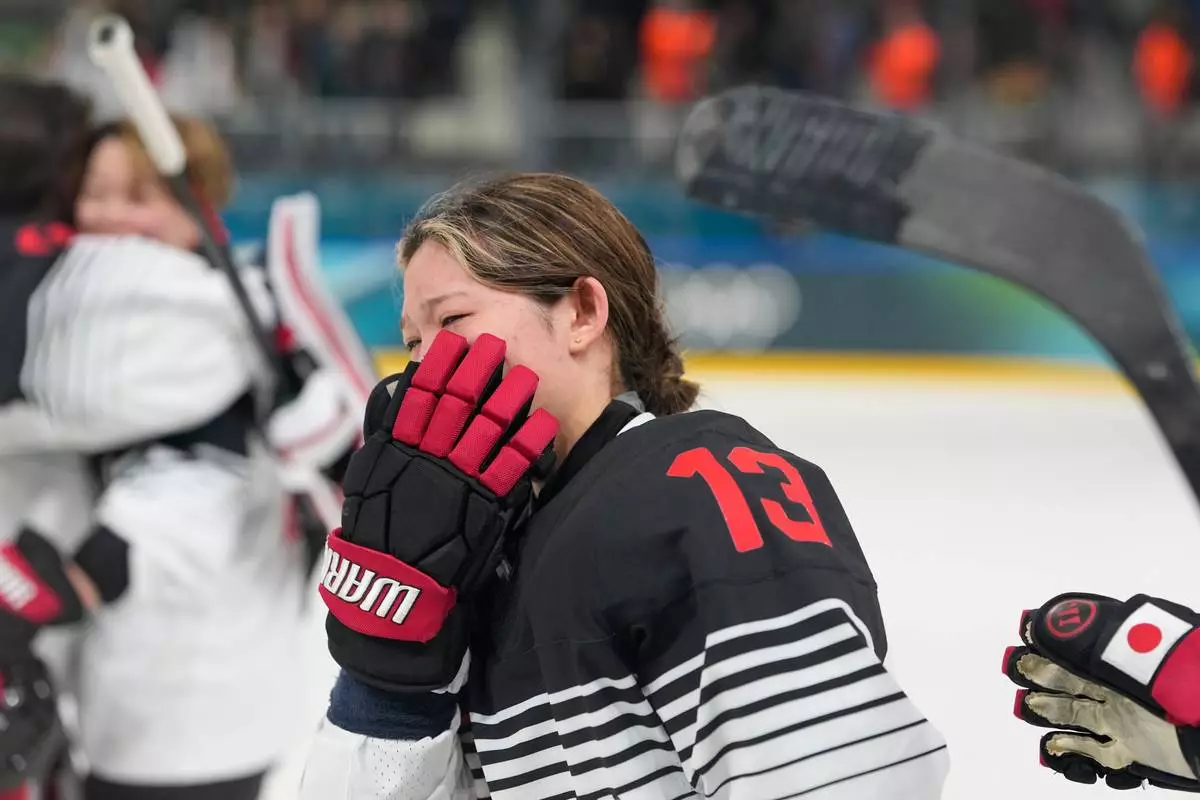Japan's Yumeka Wajima cries end of a preliminary round match of women's ice hockey between Japan and Sweden at the 2026 Winter Olympics, in Milan, Italy, Tuesday, Feb. 10, 2026. (AP Photo/Hassan Ammar)