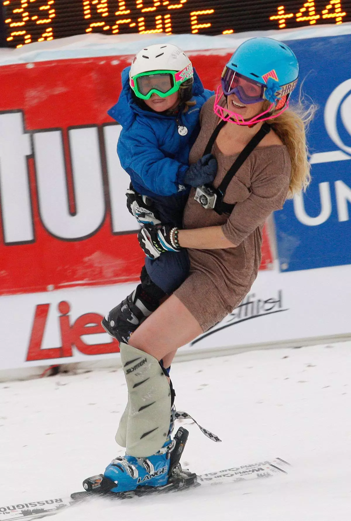 FILE - Sarah Schleper holds her son Lasse as she skies down the course during an alpine ski, women's World Cup slalom, in Lienz, Austria, Thursday, Dec. 29, 2011. (AP Photo/Armando Trovati, File)