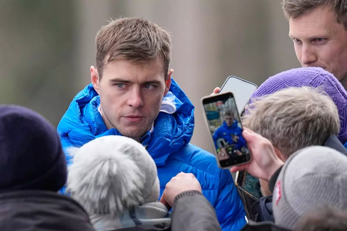 Ukraine's Vladyslav Heraskevych, left, talks to the media during a men's skeleton training session at the 2026 Winter Olympics, in Cortina d'Ampezzo, Italy, Wednesday, Feb. 11, 2026. (AP Photo/Alessandra Tarantino)