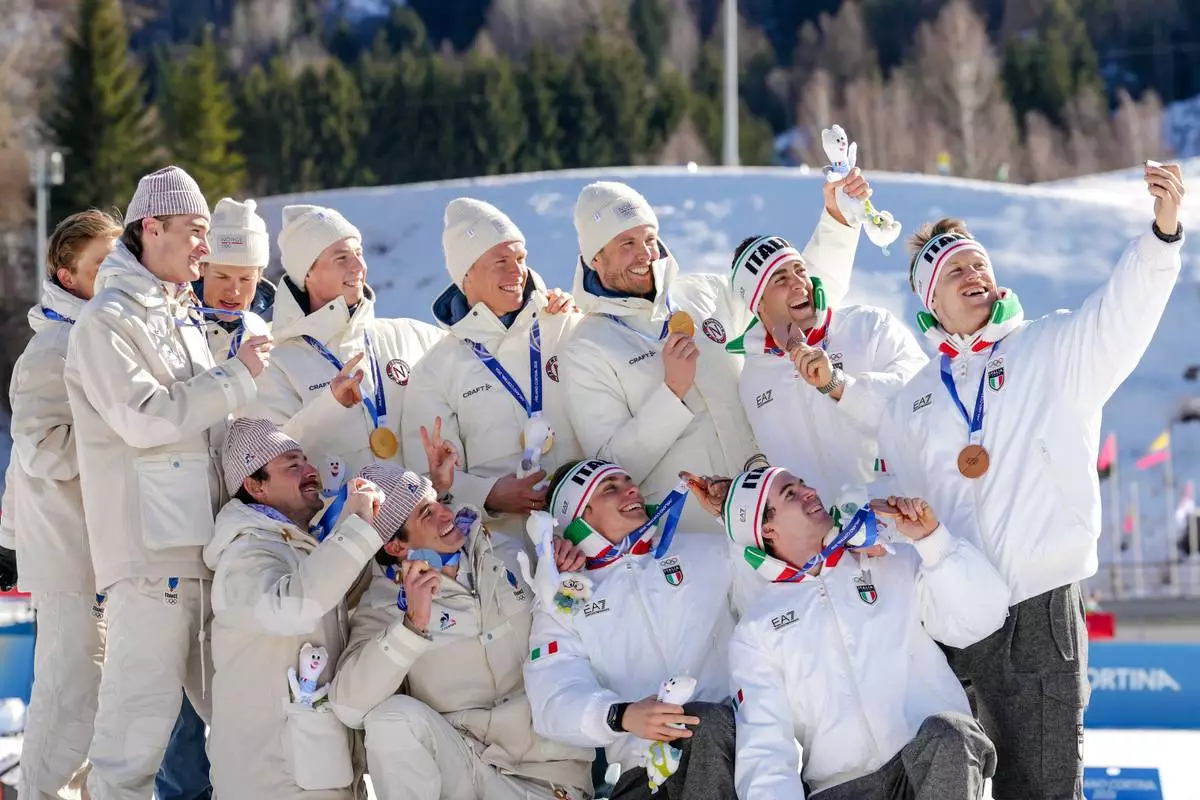 Silver medalists France, gold medalists Norway and bronze medalists Italy pose on the podium of the cross country skiing men's 4 x 7.5km relay at the 2026 Winter Olympics, in Tesero, Italy, Sunday, Feb. 15, 2026. (AP Photo/Kirsty Wigglesworth)