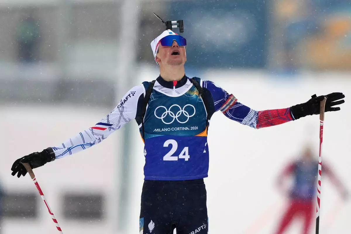 Eric Perrot, of France, reacts as he crosses the finish line to win gold in the men's 4x7.5-kilometer relay biathlon race at the 2026 Winter Olympics in Anterselva, Italy, Tuesday, Feb. 17, 2026. (AP Photo/Mosa'ab Elshamy)