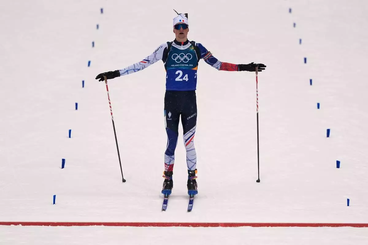 Eric Perrot, of France, skis to the finish line for gold in the men's 4x7.5-kilometer relay biathlon race at the 2026 Winter Olympics in Anterselva, Italy, Tuesday, Feb. 17, 2026. (AP Photo/Andrew Medichini)