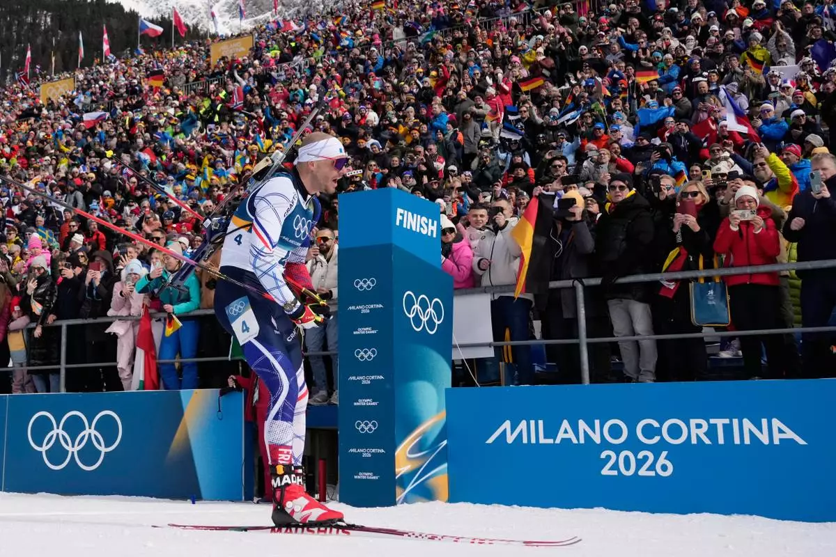 Emilien Jacquelin, of France, crosses the finish line for bronze during the men's 12.5-kilometer pursuit biathlon race at the 2026 Winter Olympics in Anterselva, Italy, Sunday, Feb. 15, 2026. (AP Photo/David J. Phillip)
