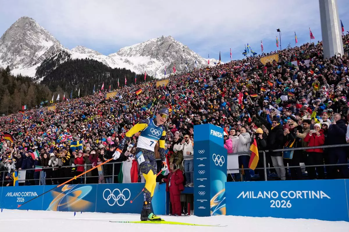 Martin Ponsiluoma, of Sweden, crosses the finish line for gold during the men's 12.5-kilometer pursuit biathlon race at the 2026 Winter Olympics in Anterselva, Italy, Sunday, Feb. 15, 2026. (AP Photo/David J. Phillip)