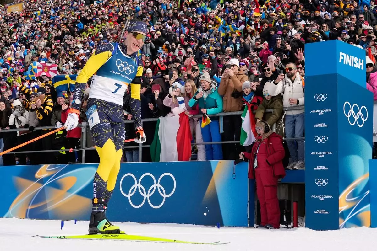 Martin Ponsiluoma, of Sweden, crosses the finish line for gold during the men's 12.5-kilometer pursuit biathlon race at the 2026 Winter Olympics in Anterselva, Italy, Sunday, Feb. 15, 2026. (AP Photo/David J. Phillip)