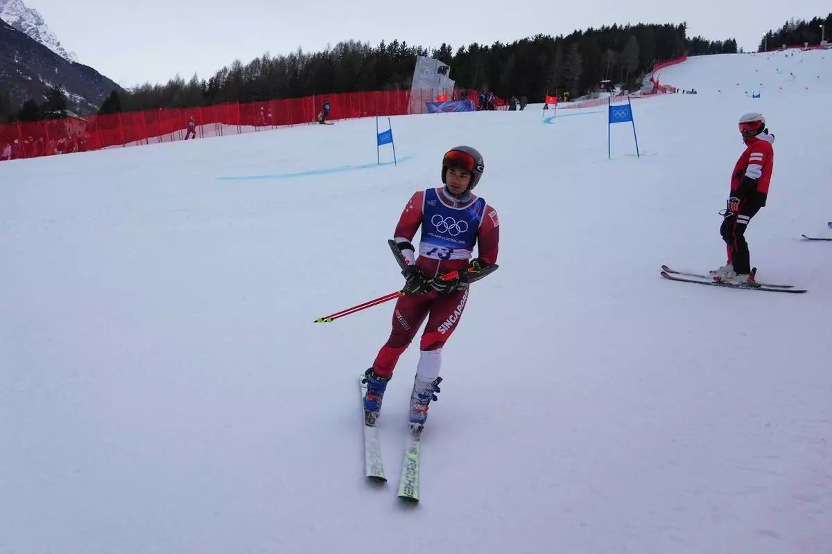 Singapore's Faiz Basha skis down after crashing during an alpine ski, men's giant slalom race, at the 2026 Winter Olympics, in Bormio, Italy, Saturday, Feb. 14, 2026. (AP Photo/Rebecca Blackwell)