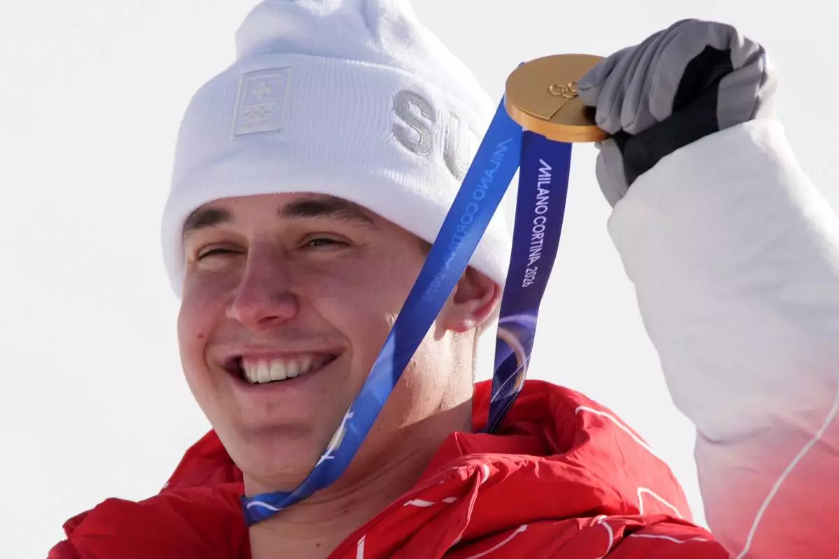 Switzerland's Franjo von Allmen shows his gold medal for an alpine ski men's downhill race, at the 2026 Winter Olympics, in Bormio, Italy, Saturday, Feb. 7, 2026. (AP Photo/Rebecca Blackwell)
