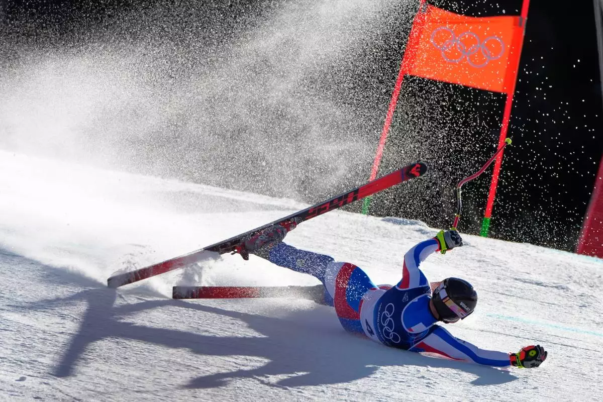 France's Maxence Muzaton falls as he speeds down the course during an alpine ski, men's downhill race, at the 2026 Winter Olympics, in Bormio, Italy, Saturday, Feb. 7, 2026. (AP Photo/John Locher)