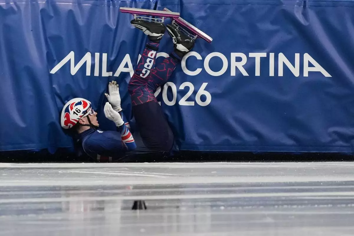 Niall Treacy of Britain crashes while competing in the men's 1000 meter short track speed skating heats at the 2026 Winter Olympics, in Milan, Italy, Tuesday, Feb. 10, 2026. (AP Photo/Stephanie Scarbrough)